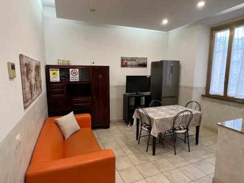 チビタベッキアにあるBe Your Home - Casa Vacanze Il Conservatorioのオレンジ色のソファとテーブルのあるリビングルーム