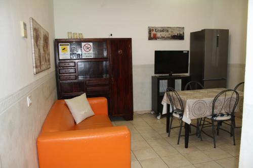 a living room with an orange couch and a table at Casa Vacanze Il Conservatorio - by Be Your Home in Civitavecchia