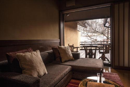 a living room with a couch and a large window at Satonoyu Waraku 13 years or older in Minamioguni
