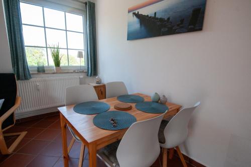 uma sala de jantar com uma mesa de madeira e cadeiras em FeWo Hartmann em Strukkamp auf Fehmarn