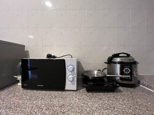 a microwave sitting on a counter next to a toaster at Perdana Serviced Apartment & Resorts in Kampung Padang Masirat