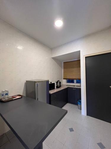 a kitchen with a counter top and a refrigerator at Perdana Serviced Apartment & Resorts in Kampung Padang Masirat