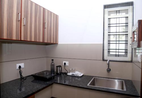 a kitchen with a sink and a window at EV StayZ in Cherai Beach
