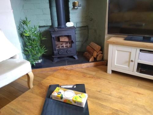 uma sala de estar com uma lareira e uma mesa em Charming Grade 2 Listed cottage, Upton-upon-Severn em Upton upon Severn