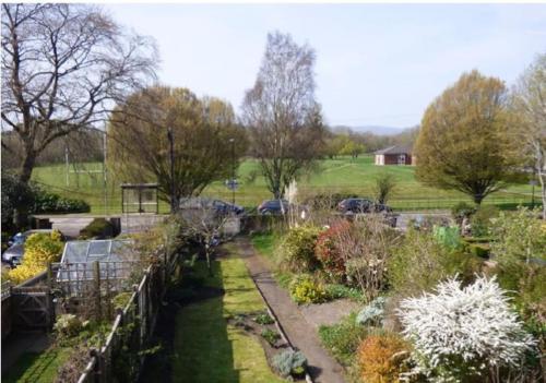 um jardim com uma cerca e muitas plantas diferentes em Charming Grade 2 Listed cottage, Upton-upon-Severn em Upton upon Severn