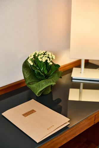 a vase of flowers sitting on top of a desk at Hotel Da Vinci in Vinci