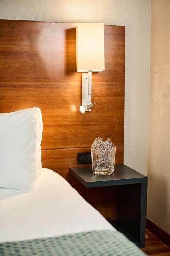 a bedroom with a bed and a nightstand with a lamp at Hotel Da Vinci in Vinci