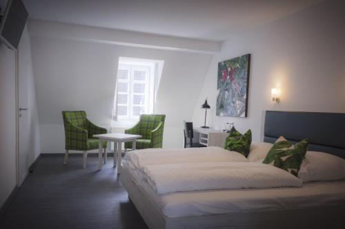 1 dormitorio con 1 cama, mesa y sillas en Hotel Schwan, en Oestrich-Winkel