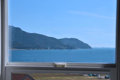a view of the ocean from a window at Ever Rose Pension in Namhae