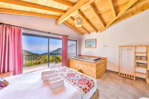 a bedroom with a bed and a balcony with a tub at Villa mirador in Kas