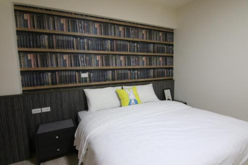 a bedroom with a bed and a large wall of books at 東港日和 in Donggang