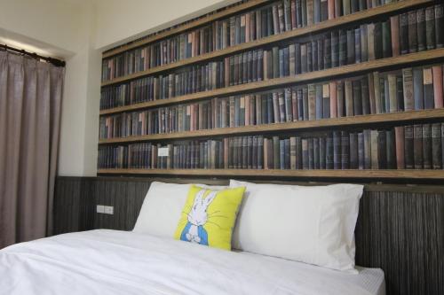 a bedroom with a bed with a book shelf with books at 東港日和 in Donggang