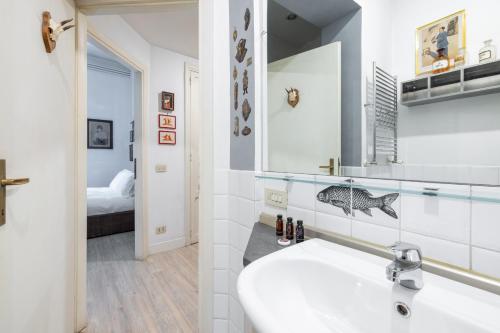 ein weißes Badezimmer mit einem Waschbecken und einem Spiegel in der Unterkunft Roma Retro Apartment - St. Peter Vatican in Rom