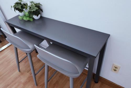 a black desk with two chairs and a plant at Ever Rose Pension in Namhae