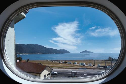 a view of the ocean from a round window at Ever Rose Pension in Namhae