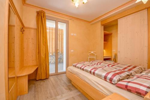 ティニャーレにあるAppartamenti Castello Resortのベッドルーム1室(ベッド2台、大きな窓付)