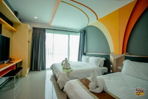 a hotel room with two beds and a window at Boat House Boutique Riverside in Talat Amphoe Nakhon Chai Si