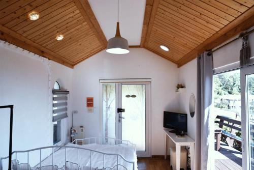 een slaapkamer met een bed en een tv in een kamer bij Ever Rose Pension in Namhae