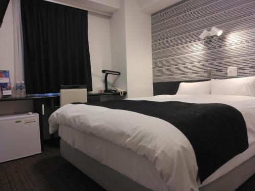 a hotel room with a large bed and a window at APA Hotel Hamamatsu Eki Minami in Hamamatsu