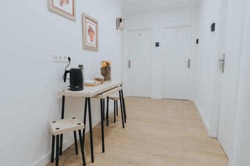 un pasillo con una mesa y dos taburetes en una habitación en Texeda Room Suites en Tejeda