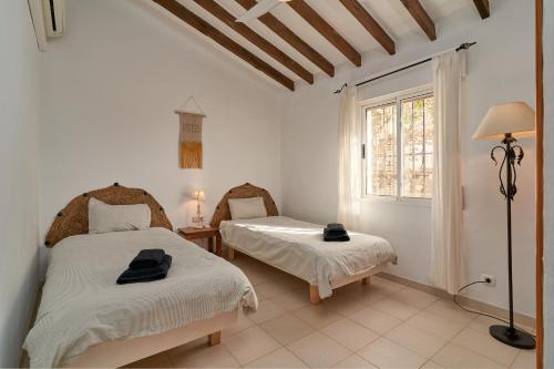 una camera con due letti e una finestra di Marvellous Private Villa Cómpeta a Cómpeta