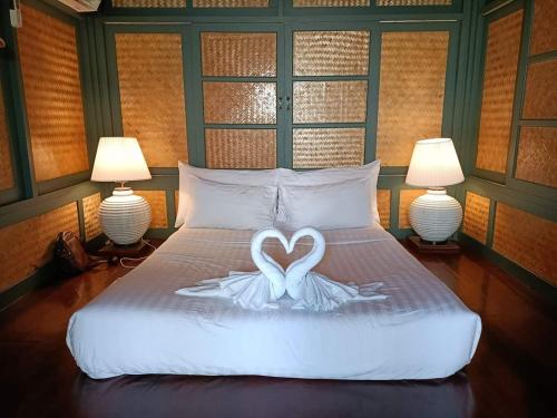 a bed with two swans in the shape of a heart at Bann Pae Cabana Hotel And Resort in Klaeng