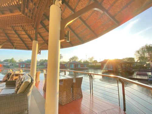 a deck with chairs and an umbrella on a boat at Boat House Boutique Riverside in Talat Amphoe Nakhon Chai Si