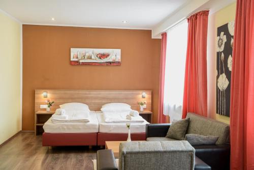 Habitación de hotel con cama y sofá en Hotel Heisede en Sarstedt