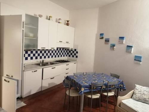 a kitchen with a table with chairs and a sink at Lulamax Sardegna in Budoni