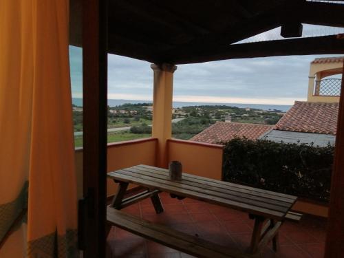a wooden bench on a balcony with a view at Lulamax Sardegna in Budoni