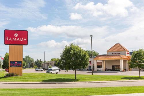 a sign for a rammada gas station next to a street at Ramada by Wyndham Sioux Falls Airport - Waterpark Resort & Event Center in Sioux Falls