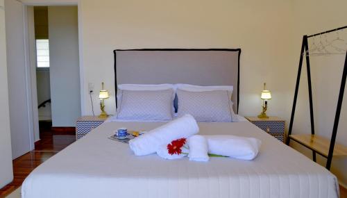 een slaapkamer met een bed met witte lakens en kussens bij Ef Zin Villa by Corfuescapes in Sidari