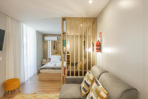 a living room with a couch and a bedroom at Signature Aveiro Flat incl Parking by Home Sweet Home Aveiro in Aveiro