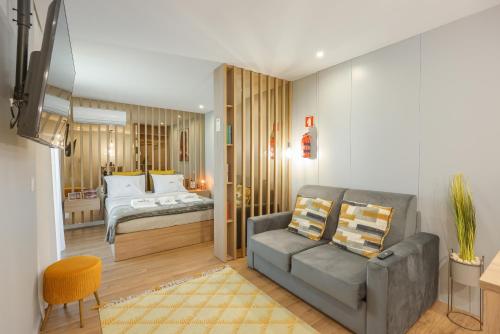 a living room with a couch and a bed at Signature Aveiro Flat incl Parking by Home Sweet Home Aveiro in Aveiro