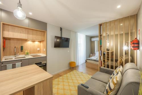 a living room with a couch and a kitchen and a bedroom at Signature Aveiro Flat incl Parking by Home Sweet Home Aveiro in Aveiro