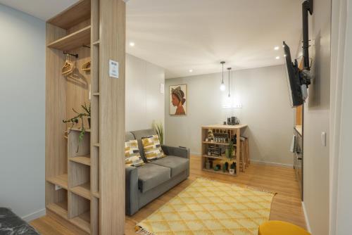 a living room with a couch and a television at Signature Aveiro Flat incl Parking by Home Sweet Home Aveiro in Aveiro