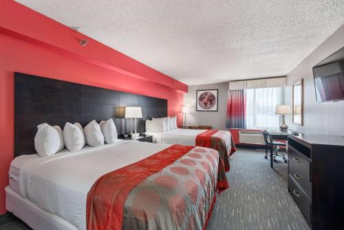 Кровать или кровати в номере Ramada by Wyndham Sioux Falls Airport - Waterpark Resort & Event Center