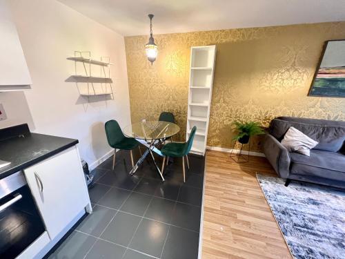 cocina y sala de estar con mesa y sofá en 2 Bedroom Apartment near Olympic Park with Free Parking, en Londres