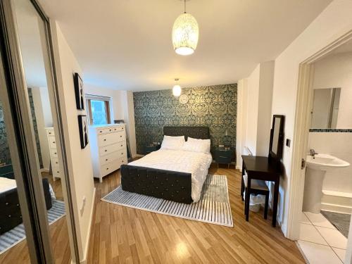 1 dormitorio con cama, lavabo y escritorio en 2 Bedroom Apartment near Olympic Park with Free Parking, en Londres
