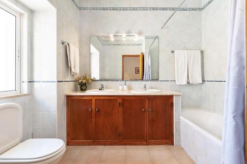 bagno con lavandino, vasca e servizi igienici di Casa da Bia by OCvillas ad Albufeira