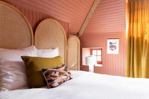 sypialnia z białym łóżkiem i drewnianą ścianą w obiekcie Séjours Maison Baluchon w mieście Chaumont