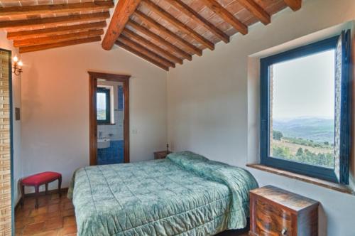 a bedroom with a bed and a large window at Le 7 Camicie in Castelnuovo dellʼAbate