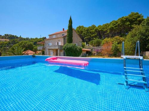 a large swimming pool with a pink inflatable at Palm Tree Apartments in Dubrovnik