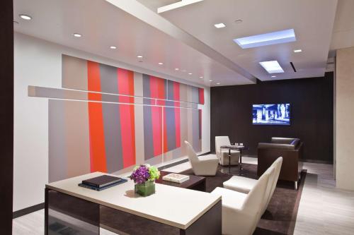 an office with a table and chairs and a tv at Hyatt Grand Central New York in New York