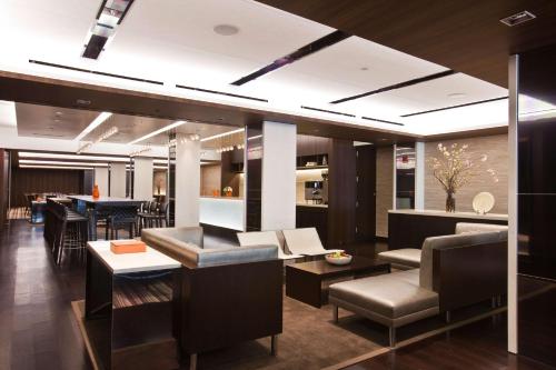 a lobby with couches and a bar with a table at Hyatt Grand Central New York in New York