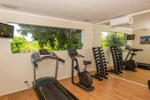 a gym with treadmills and exercise bikes in a room at The Cellars-Hohenort in Cape Town