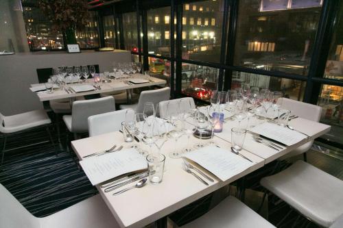 a dining room with tables and chairs with wine glasses at Hyatt Grand Central New York in New York