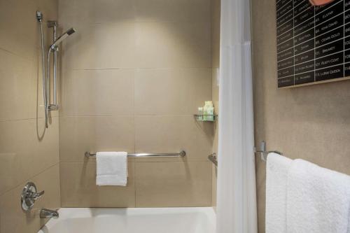 a bathroom with a shower and a toilet and towels at Hyatt Grand Central New York in New York