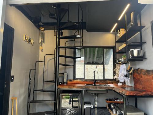 a kitchen in a tiny house with a ladder at Container-Spa quente, projetor cine, lareira, churrasqueira-20km de Brotas in Torrinha