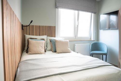 a large bed in a room with a window at Rising Sun Westende in Middelkerke